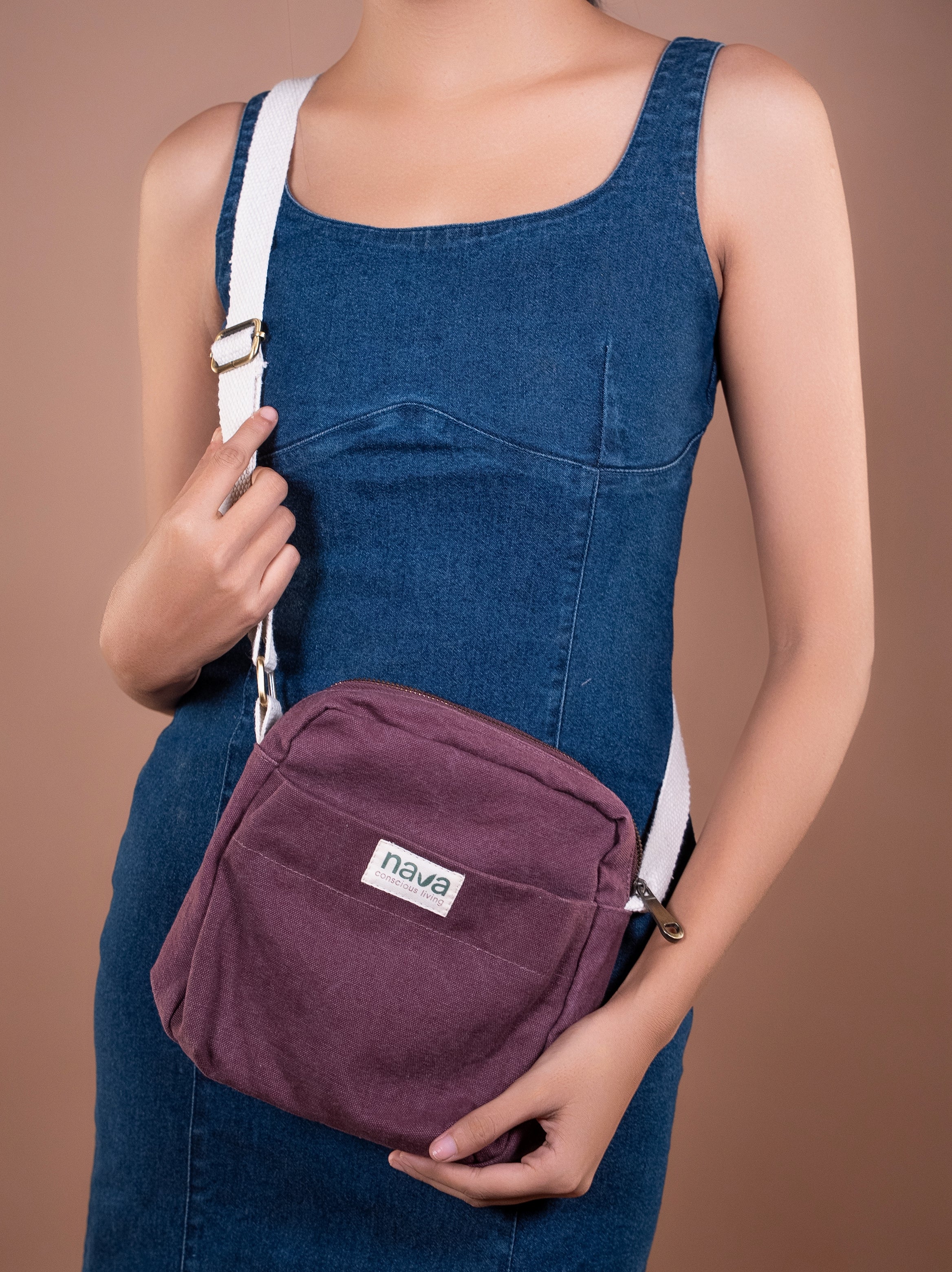 Person carrying a Nava Eco-friendly cotton crossbody bag in red for travel 